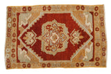 Vintage distressed Oushak rug featuring a cherry red medallion and unique serpent-like arabesques, 1'9