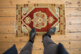 Vintage Distressed Oushak rug mat with cherry red medallion and serpentine corner arabesques.