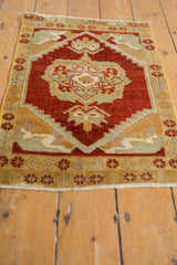 Vintage distressed Oushak rug mat with cherry red field, floral medallion, and timeworn texture.