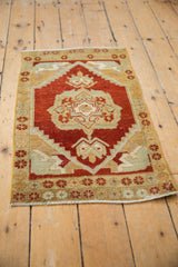 Distressed Turkish Oushak rug corner, unique serpent-like arabesques in cherry red and sand.