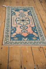 Distressed Oushak rug detail showing pale blush and blue floral pinwheel, even wear.