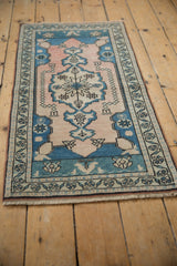 Distressed vintage Oushak runner corner, pale blush field with blue floral border.