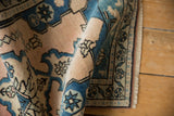 Textured pile of vintage Oushak runner displaying blush, sky blue, and charcoal floral motifs.