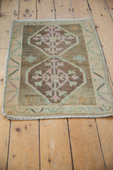 Distressed Kars rug with abrashed field, pink, and seafoam green vine border.