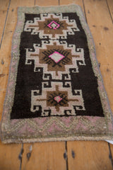 Distressed Kars rug with chocolate, beige, pink geometric gul and hook motifs.