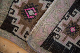 Distressed Kars rug pile with bright pink gul motif, hook details, and secured side.