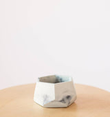 White concrete air plant holder with a gray marbled pattern and faceted sides.