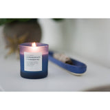 Burning lemongrass tangerine soy candle in frosted blue gradient glass.