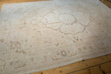 Distressed Oushak rug border with faded ivory and pale apricot meandering vines.