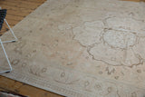 Distressed vintage Oushak rug with faded vine patterns and subtle tone-on-tone border.