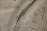 Distressed Oushak carpet texture with subtle vinery, soft ivory, pale apricot tones, showing wear.