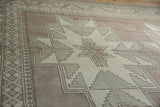 Distressed Oushak carpet with primitive geometric patterns in mauve, beige, and seafoam green.