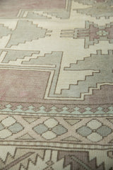 Distressed Oushak rug detail: serrated leaf border and geometric pawn motif in muted tones.