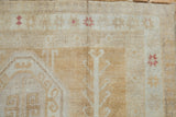 Distressed Oushak rug pile with visible knot heads and geometric ivory, gold, raspberry motifs.