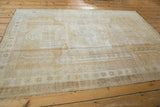 Distressed Oushak rug with even wear, subtle pile texture, and faded Sewan Kazak motifs.