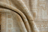 Textured pile of the distressed Oushak rug, showing even wear in ivory and gold.