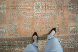 Elongated geometric patterns with pale terracotta and ivory hues showing even wear.