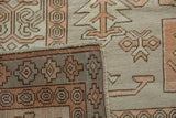 Distressed vintage Oushak rug's folded edge, showing geometric pattern and blue-green detail.