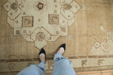 Vintage Distressed Oushak carpet with heavily abrashed field showing faded neutral geometric motifs.