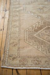 Distressed Oushak runner side edge showing worn texture and geometric beige brown pattern.