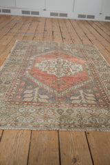 Distressed Oushak rug corner, worn dusty rose and beige pile with visible foundation.