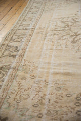 Vintage distressed Oushak carpet, low pile showing faded ivory and subtle patterns.