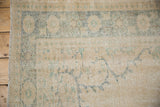 Distressed Oushak carpet showing worn pile, faint foundation, and faded patterns with intact selvage.