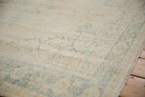 Distressed Oushak carpet pile with faded ivory and green-blue curvilinear patterns, showing side selvage.