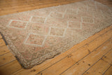 Distressed vintage Oushak runner detail of faded ivory, beige diamond motifs with even wear.