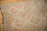 Distressed Oushak rug detail in muted ivory, beige, and pale sandalwood geometric patterns.
