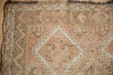Faded geometric patterns and distressed texture on this vintage Oushak rug.