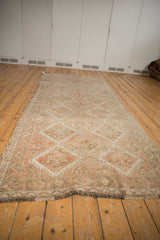 Secured end with dark fringe and intact selvage of a vintage distressed Oushak runner.