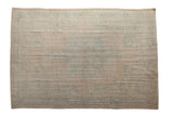 Vintage distressed Oushak carpet with a faint sea foam green medallion on a soft ivory and beige field.