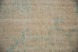 Detailed texture of a distressed Turkish Oushak carpet showing wear to the knot heads.