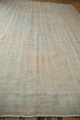 Textured wear and visible knot heads on a distressed vintage Oushak carpet from a low angle.