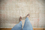 Distressed Oushak rug surface, showing significant pile wear and exposed foundation in muted pastels.