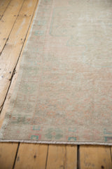 Distressed Oushak rug texture showing foundation wear, faded blush and pale turquoise.