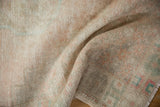 Hand-knotted Oushak rug's woven reverse side, showing intricate foundation, fringe, and subtle hues.