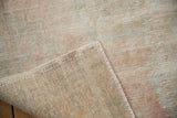 Distressed vintage Turkish Oushak rug showing significant wear to pile, exposed foundation, and original selvage.
