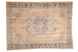 Distressed vintage Oushak carpet with faded roundel medallion and floral motifs in soft peach and cobalt blue.
