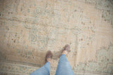 Worn pile of a distressed vintage Oushak carpet, with faded beige and aqua floral patterns.
