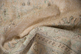 Distressed Oushak rug with textured pile, showing foundational wear and faded green patterns.