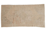 Vintage distressed Oushak rug runner with a subtle scalloped medallion in neutral ivory and sand tones.