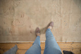 A personal perspective of the low-pile, hand-knotted texture on a distressed vintage Oushak rug.