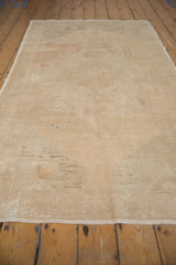 Low angle view of the distressed vintage Oushak runner showing its sandy texture and low pile.
