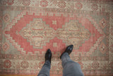 Distressed Oushak rug with pale ruby red grapefruit field and stepped contour medallion.