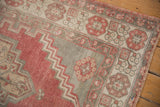 Worn border with geometric floral motifs and intact selvedge on a distressed Oushak rug.