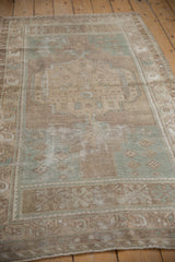 Distressed vintage Oushak rug detail with textured pile, visible wear, and soft beige and seafoam patterns.