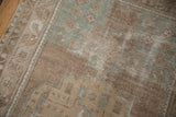 Detail of the distressed Oushak rug's muted beige, seafoam green, and brown pile with visible foundation.