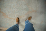 A top-down view of the distressed Oushak carpet's soft, low pile with even wear.
